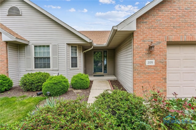 209 E Sawmill Rd, Findlay, OH 45840 - property entrance featuring a garage, a shingled roof, and brick siding