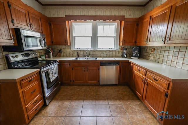 5243 Flanders Rd, Toledo, OH 43623 - kitchen with stainless steel appliances, a sink, tasteful backsplash, and brown cabinetry