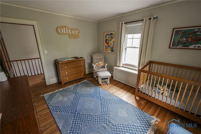 5243 Flanders Rd, Toledo, OH 43623 - bedroom featuring radiator, crown molding, wood finished floors, a crib, and baseboards