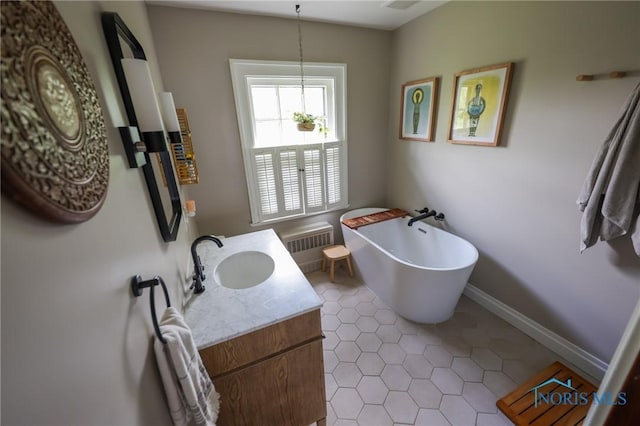 5243 Flanders Rd, Toledo, OH 43623 - bathroom featuring radiator, vanity, a freestanding bath, and tile patterned flooring