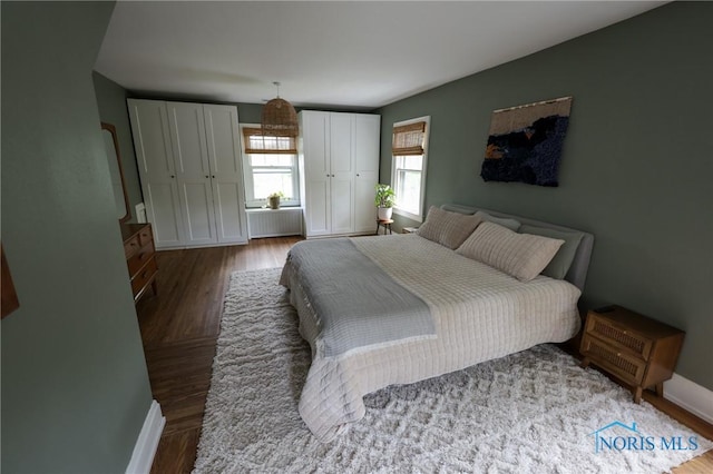 5243 Flanders Rd, Toledo, OH 43623 - bedroom with radiator, multiple closets, baseboards, and wood finished floors