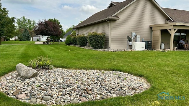 12327 Buckeye Dr, Paulding, OH 45879 - view of home's exterior featuring a shingled roof and a lawn