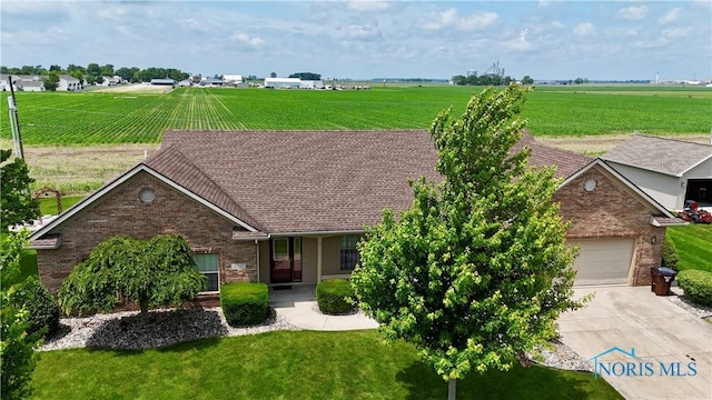 12327 Buckeye Dr, Paulding, OH 45879 - view of front of house with brick siding, concrete driveway, and a front lawn
