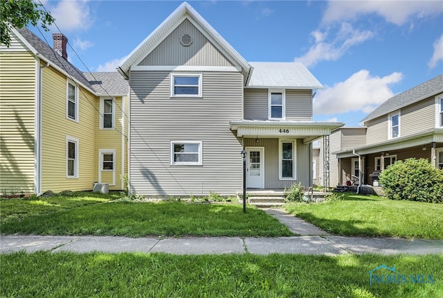 446 Center St, Findlay, OH 45840 - view of front of home featuring a front yard, a porch, board and batten siding, and metal roof