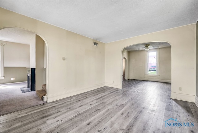 446 Center St, Findlay, OH 45840 - unfurnished room with a ceiling fan, arched walkways, wood finished floors, a textured ceiling, and baseboards