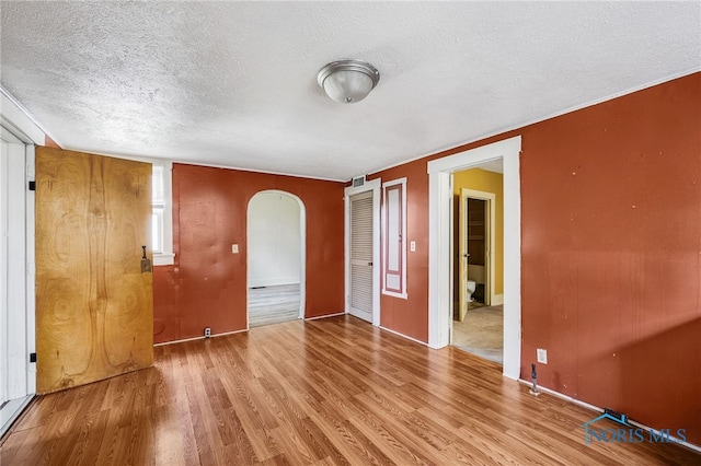 446 Center St, Findlay, OH 45840 - empty room with a textured ceiling, arched walkways, and wood finished floors