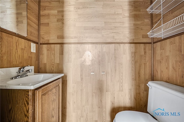 446 Center St, Findlay, OH 45840 - bathroom featuring toilet, vanity, and wood walls