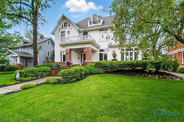 1100 S Main St, Findlay, OH 45840 - victorian house with a balcony, a front yard, and brick siding