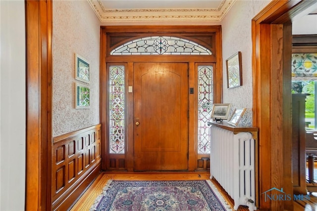 1100 S Main St, Findlay, OH 45840 - foyer featuring light wood-style floors, radiator heating unit, a textured wall, and crown molding