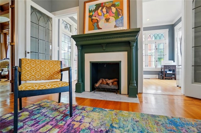 1100 S Main St, Findlay, OH 45840 - sitting room featuring a fireplace with flush hearth, crown molding, and wood finished floors