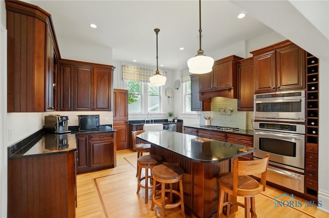 1100 S Main St, Findlay, OH 45840 - kitchen featuring a warming drawer, dark countertops, a kitchen breakfast bar, decorative backsplash, and recessed lighting