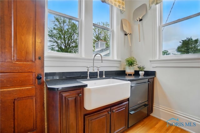 1100 S Main St, Findlay, OH 45840 - kitchen featuring a sink, healthy amount of natural light, dark countertops, and light wood finished floors
