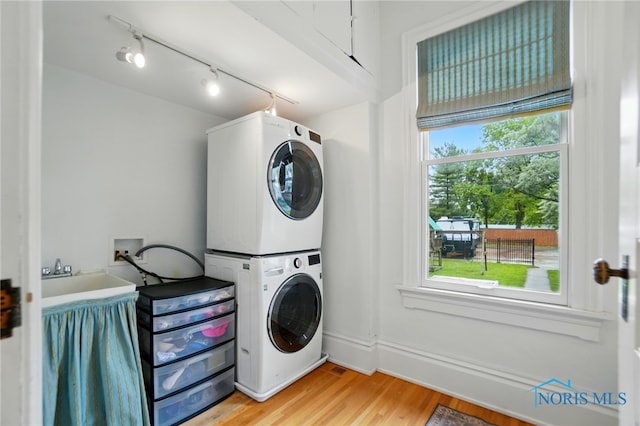 1100 S Main St, Findlay, OH 45840 - washroom featuring stacked washer / dryer, light wood finished floors, and track lighting