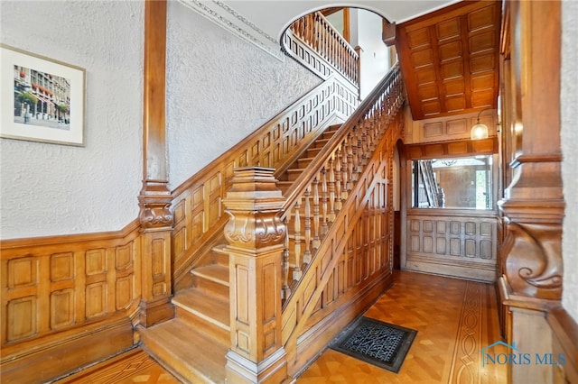 1100 S Main St, Findlay, OH 45840 - stairs featuring a textured wall, a towering ceiling, a wainscoted wall, and wood walls