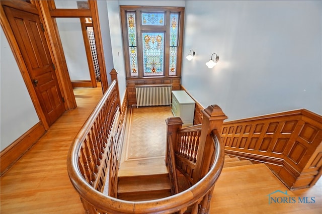 1100 S Main St, Findlay, OH 45840 - staircase featuring radiator heating unit, wood finished floors, and baseboards
