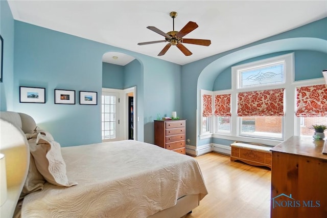 1100 S Main St, Findlay, OH 45840 - bedroom with light wood-style flooring, arched walkways, and a ceiling fan