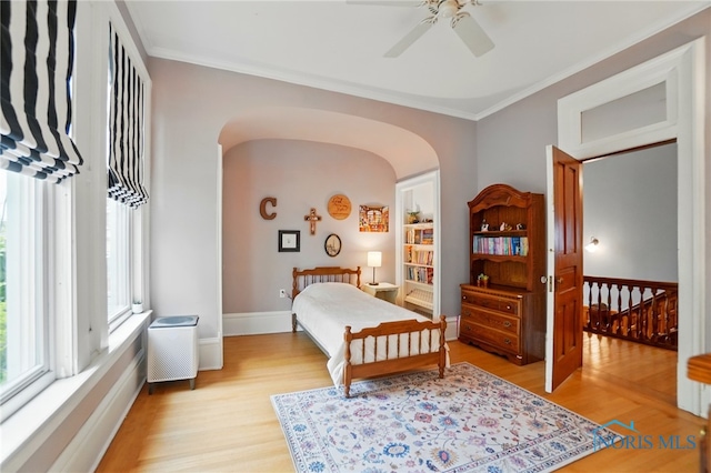 1100 S Main St, Findlay, OH 45840 - bedroom featuring arched walkways, light wood-style floors, crown molding, baseboards, and a ceiling fan