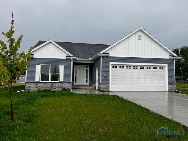 4015 E Plaza Blvd, Northwood, OH 43619 - view of front facade with an attached garage, a front lawn, driveway, stone siding, and a shingled roof