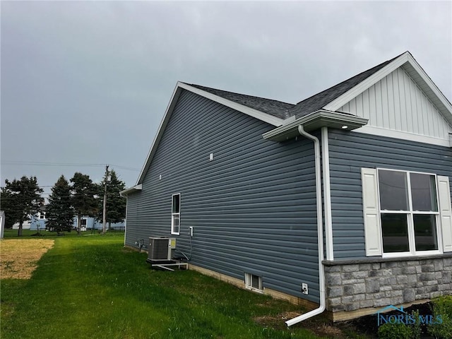 4015 E Plaza Blvd, Northwood, OH 43619 - view of side of home featuring central AC unit, a yard, board and batten siding, and roof with shingles