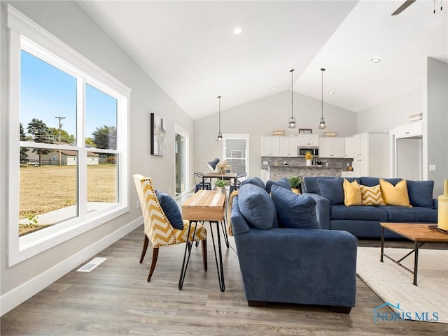 4015 E Plaza Blvd, Northwood, OH 43619 - living room with plenty of natural light, light wood finished floors, ceiling fan, baseboards, and high vaulted ceiling