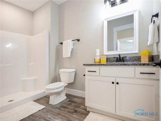 4015 E Plaza Blvd, Northwood, OH 43619 - full bath featuring toilet, wood finished floors, a stall shower, vanity, and baseboards