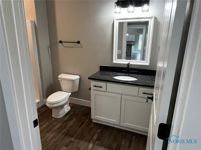 4015 E Plaza Blvd, Northwood, OH 43619 - bathroom with toilet, wood finished floors, vanity, and baseboards