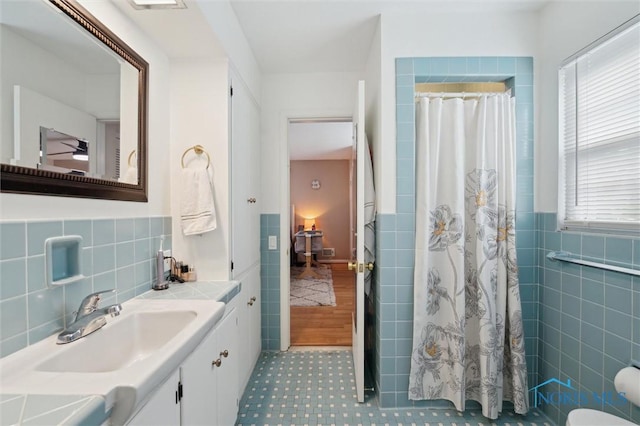 2222 Talmadge Rd, Ottawa Hills, OH 43606 - full bath featuring tile walls, plenty of natural light, a shower with shower curtain, vanity, and a wainscoted wall