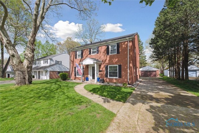 2222 Talmadge Rd, Ottawa Hills, OH 43606 - view of front of house with brick siding, an outdoor structure, a front yard, and a garage