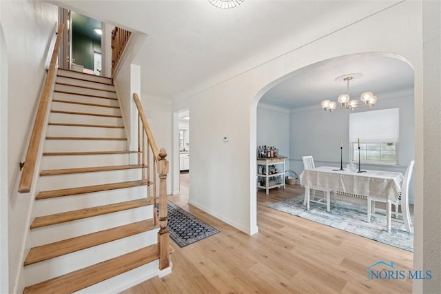 2222 Talmadge Rd, Ottawa Hills, OH 43606 - staircase featuring wood finished floors, arched walkways, a chandelier, and baseboards