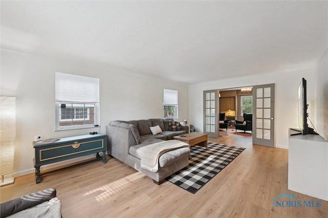2222 Talmadge Rd, Ottawa Hills, OH 43606 - living room featuring french doors, healthy amount of natural light, light wood-style flooring, and baseboards