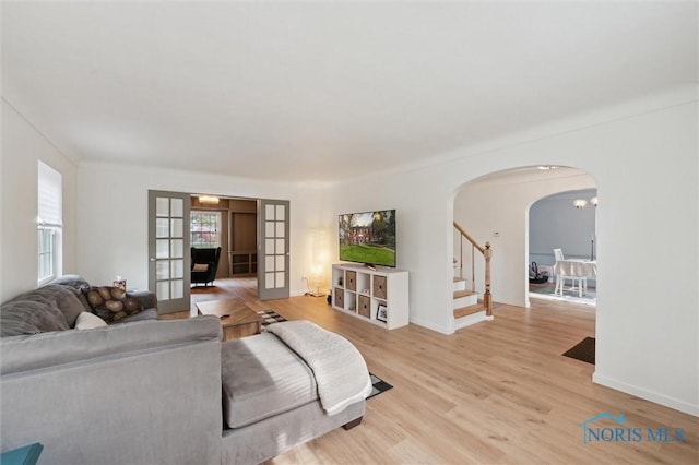 2222 Talmadge Rd, Ottawa Hills, OH 43606 - living room featuring arched walkways, light wood-style flooring, stairs, and baseboards