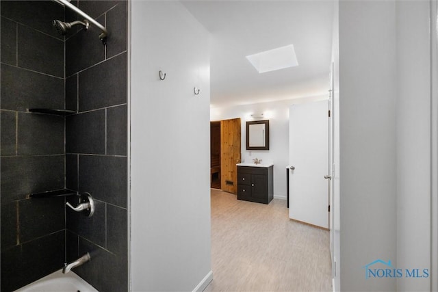 4550 W Sylvania Ave, Toledo, OH 43623 - bathroom featuring a skylight, vanity, shower / tub combination, baseboards, and wood finished floors