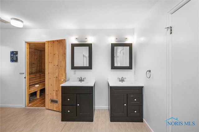 4550 W Sylvania Ave, Toledo, OH 43623 - bathroom with two vanities, wood finished floors, and baseboards