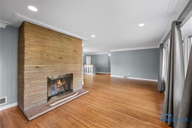 4550 W Sylvania Ave, Toledo, OH 43623 - unfurnished living room featuring baseboards, wood finished floors, ornamental molding, a stone fireplace, and recessed lighting