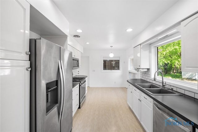 4550 W Sylvania Ave, Toledo, OH 43623 - kitchen with stainless steel appliances, a sink, dark countertops, tasteful backsplash, and recessed lighting