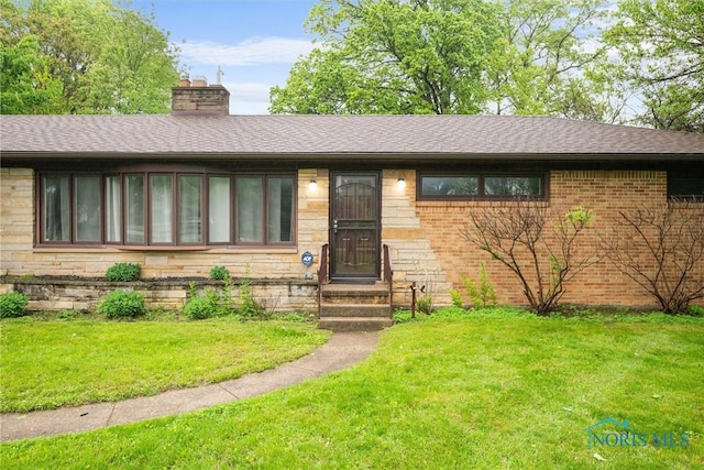 4550 W Sylvania Ave, Toledo, OH 43623 - view of front of home featuring a front yard, a chimney, brick siding, and roof with shingles