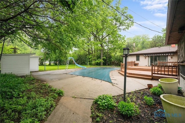 4550 W Sylvania Ave, Toledo, OH 43623 - view of swimming pool with a water slide, a patio, a covered pool, and a wooden deck