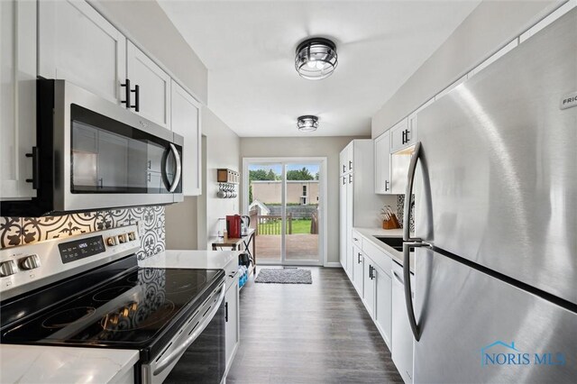 513 Bay River Ct, Maumee, OH 43537 - kitchen featuring appliances with stainless steel finishes, dark wood-type flooring, white cabinetry, and tasteful backsplash