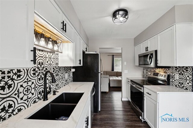 513 Bay River Ct, Maumee, OH 43537 - kitchen featuring appliances with stainless steel finishes, a sink, backsplash, light stone countertops, and white cabinets