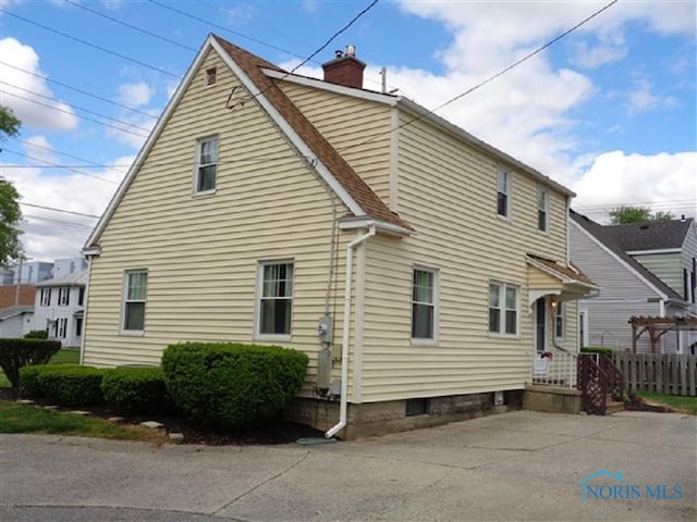 934 E 4th St, Ottawa, OH 45875 - view of side of home with a chimney and roof with shingles