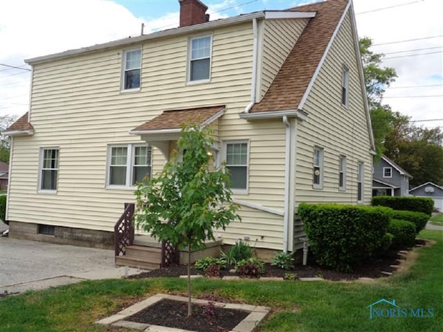 934 E 4th St, Ottawa, OH 45875 - rear view of property featuring a chimney, a shingled roof, and a yard