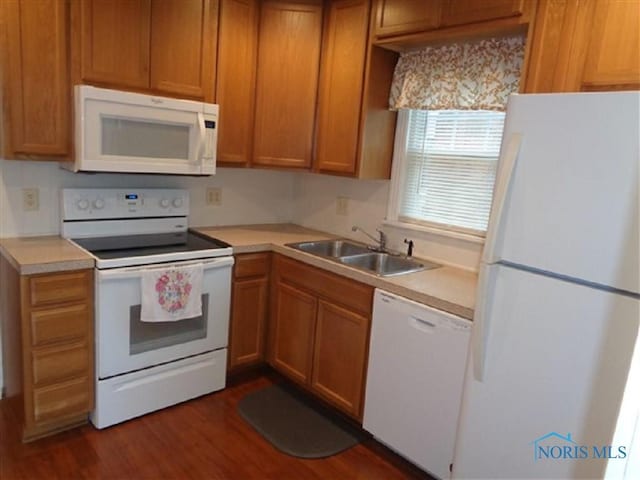 934 E 4th St, Ottawa, OH 45875 - kitchen with white appliances, a sink, dark wood-style flooring, light countertops, and brown cabinets