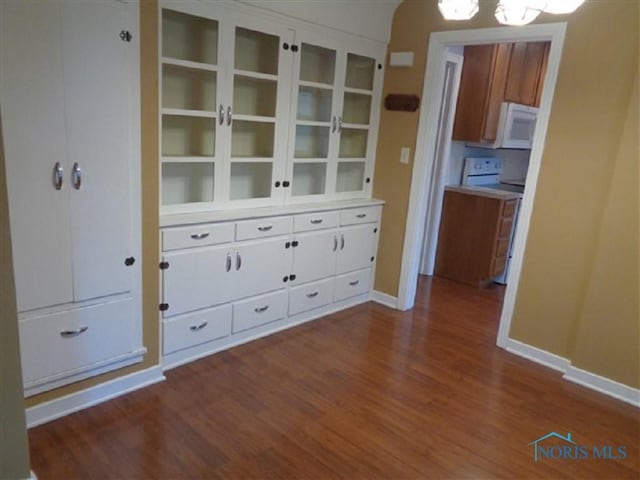 934 E 4th St, Ottawa, OH 45875 - unfurnished dining area featuring dark wood-type flooring and baseboards