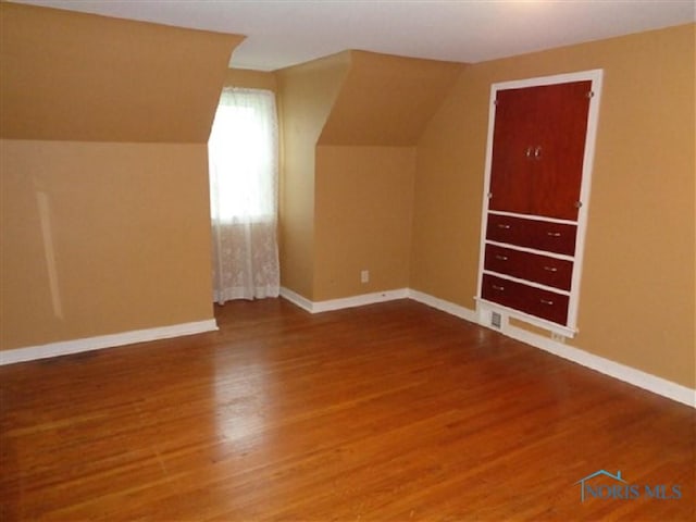 934 E 4th St, Ottawa, OH 45875 - additional living space featuring wood finished floors, vaulted ceiling, and baseboards