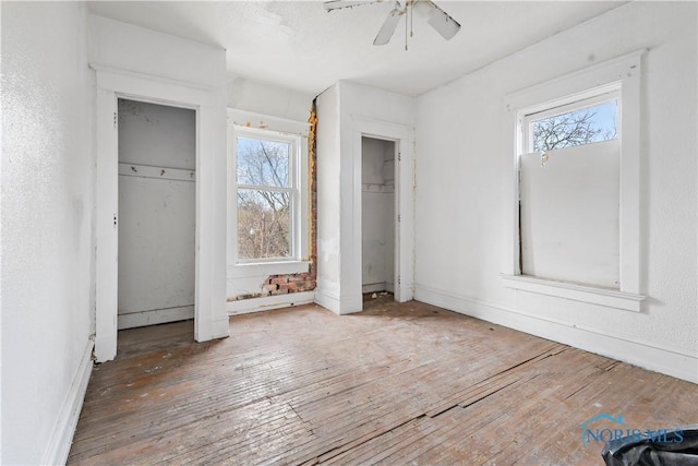 128 W Bancroft St, Toledo, OH 43620 - unfurnished bedroom with hardwood / wood-style floors, two closets, and ceiling fan