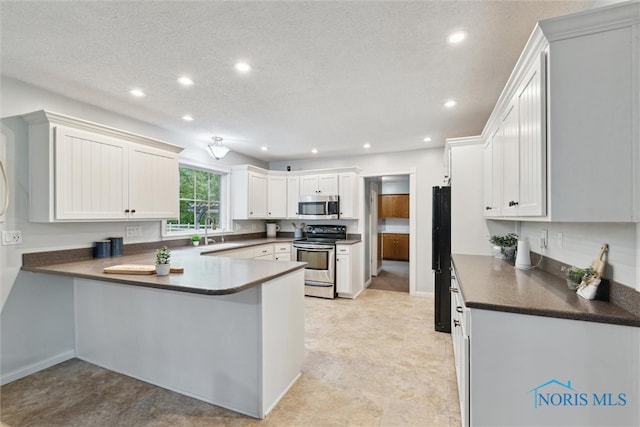 21265 State Route 2, Archbold, OH 43502 - kitchen featuring stainless steel appliances, a peninsula, recessed lighting, dark countertops, and a sink
