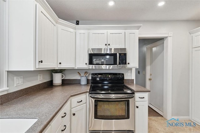 21265 State Route 2, Archbold, OH 43502 - kitchen with stainless steel appliances, white cabinets, recessed lighting, dark countertops, and light tile patterned flooring
