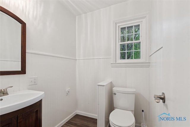 21265 State Route 2, Archbold, OH 43502 - half bathroom featuring vanity, toilet, wood finished floors, and baseboards