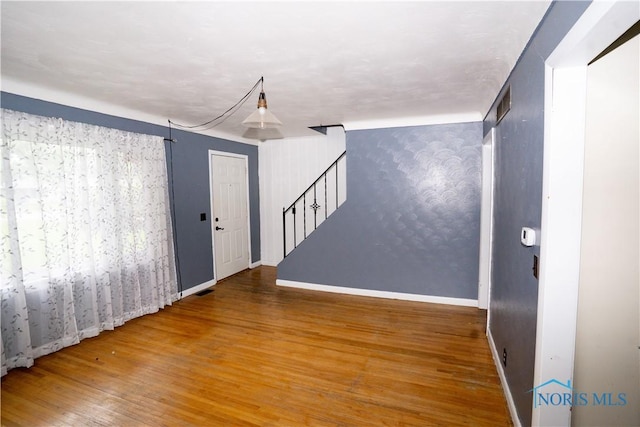 1702 E Hopkins St, Defiance, OH 43512 - spare room with wood finished floors, stairs, and baseboards