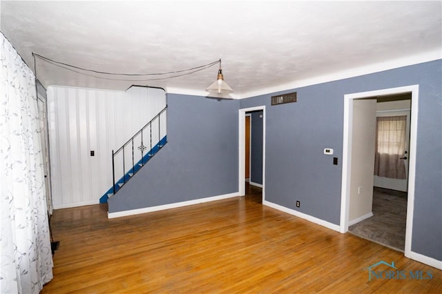 1702 E Hopkins St, Defiance, OH 43512 - spare room featuring baseboards, wood finished floors, and stairway